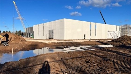 Construction photo of building external walls on site of dirt