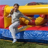 Child bouncing out of the inflatable onto grass