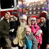 Santa visits a family in front of a firetruck