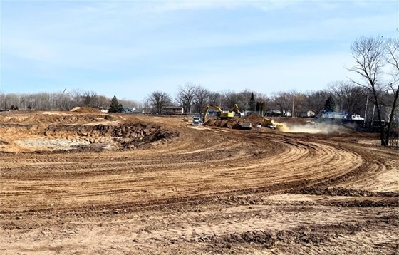 Construction vehicles work on dirt work site