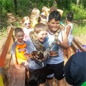 Large snake held by two boys