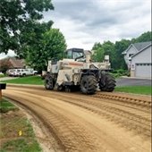 Construction vehicle on road torn up in residential neighborhood