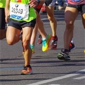A paved trail with people running by